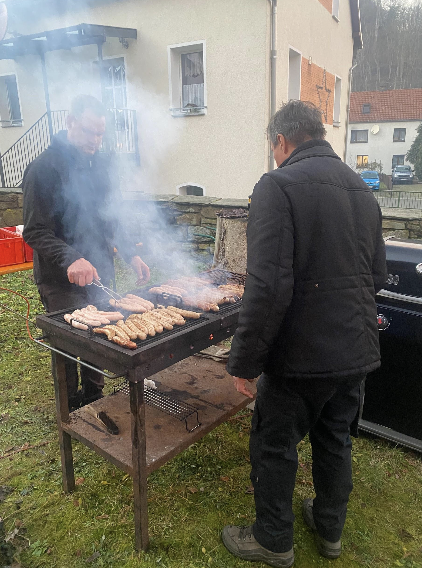 Am Grill des HOKEKI e.V. auf dem Weihnachtsmarkt in Schaala werden Bratwürste zubereitet