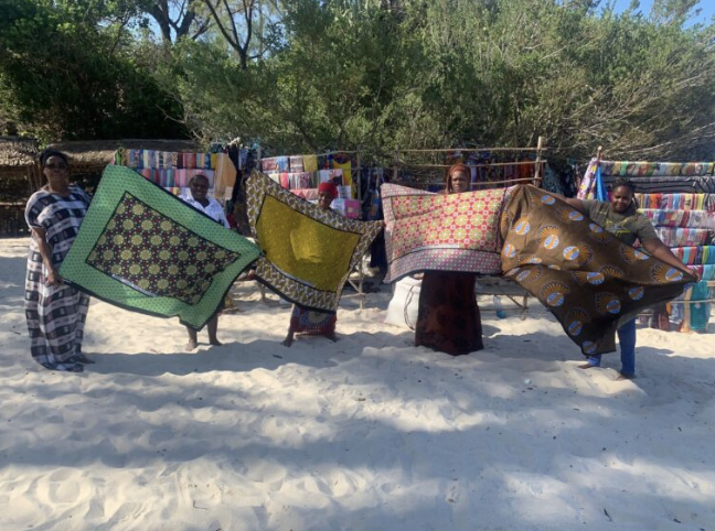 Frauen in Kenia präsentieren selbst genähte Decken aus bunten Stoffen