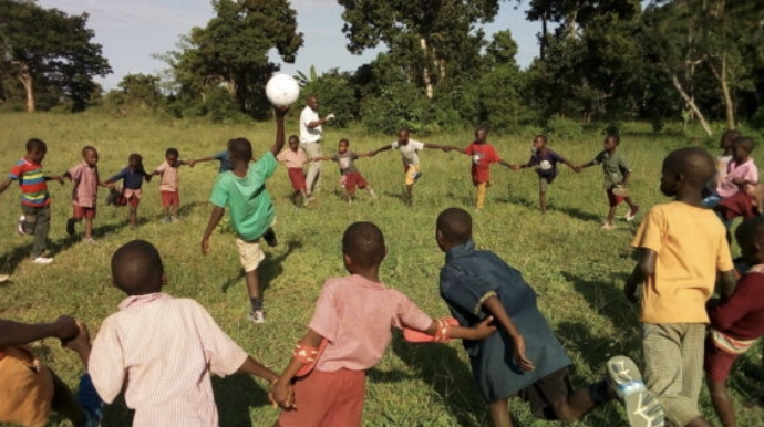 Kinder spielen Fußball auf der Wiese am St. Michael Community Day Care Center in Kenia