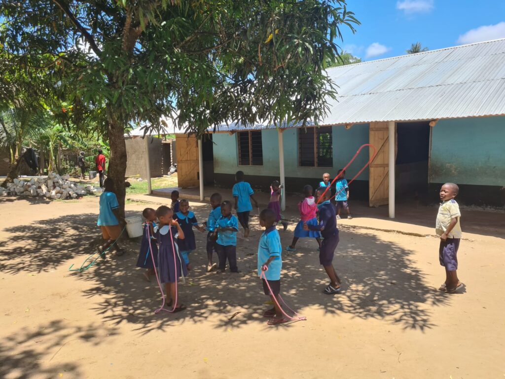 Kinder spielen mit den mitgebrachten Springseilen auf dem Schulhof